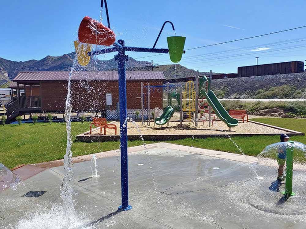 The splash pad next to the playground at CASTLE GATE RV PARK & CAMPGROUND