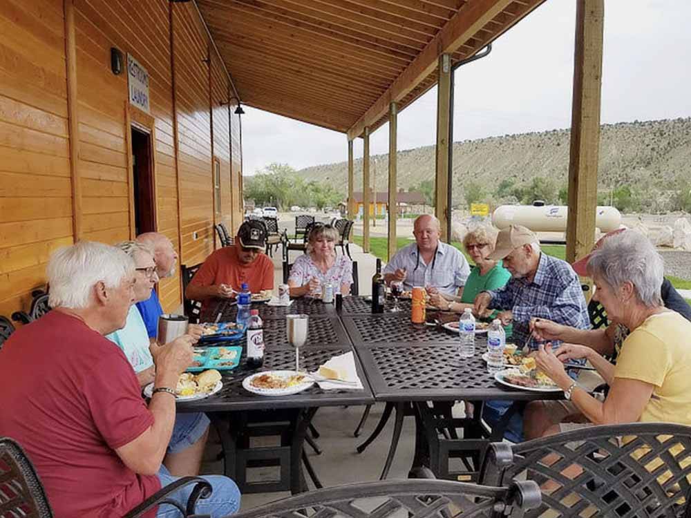 A group of people enjoying food at CASTLE GATE RV PARK & CAMPGROUND