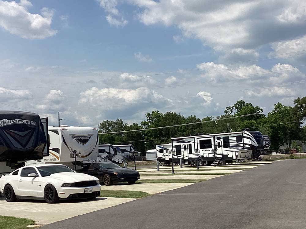 A row of filled paved RV sites at BLUE HERON RV PARK