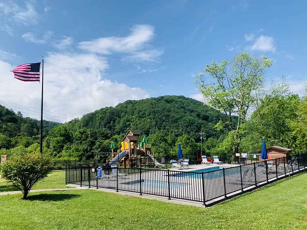 Pool, playground and American flag at GATEWAY TO THE SMOKIES RV PARK & CAMPGROUND