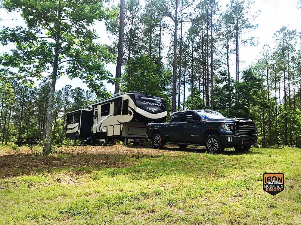 A truck and fifth wheel trailer in a primitive campsite at IRON MOUNTAIN RESORT