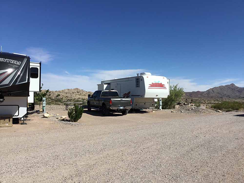 A couple of RVs in campsites at DESERT VIEW RV PARK