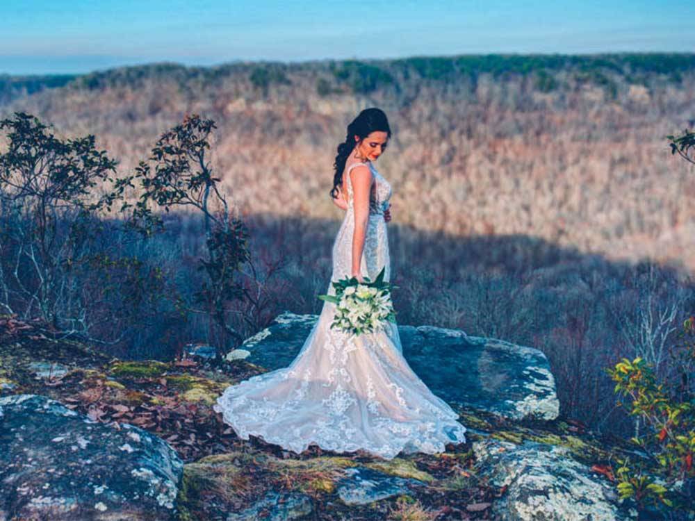 A lady in a wedding dress standing atop a mountain at BIGFOOT ADVENTURE RV PARK & CAMPGROUND