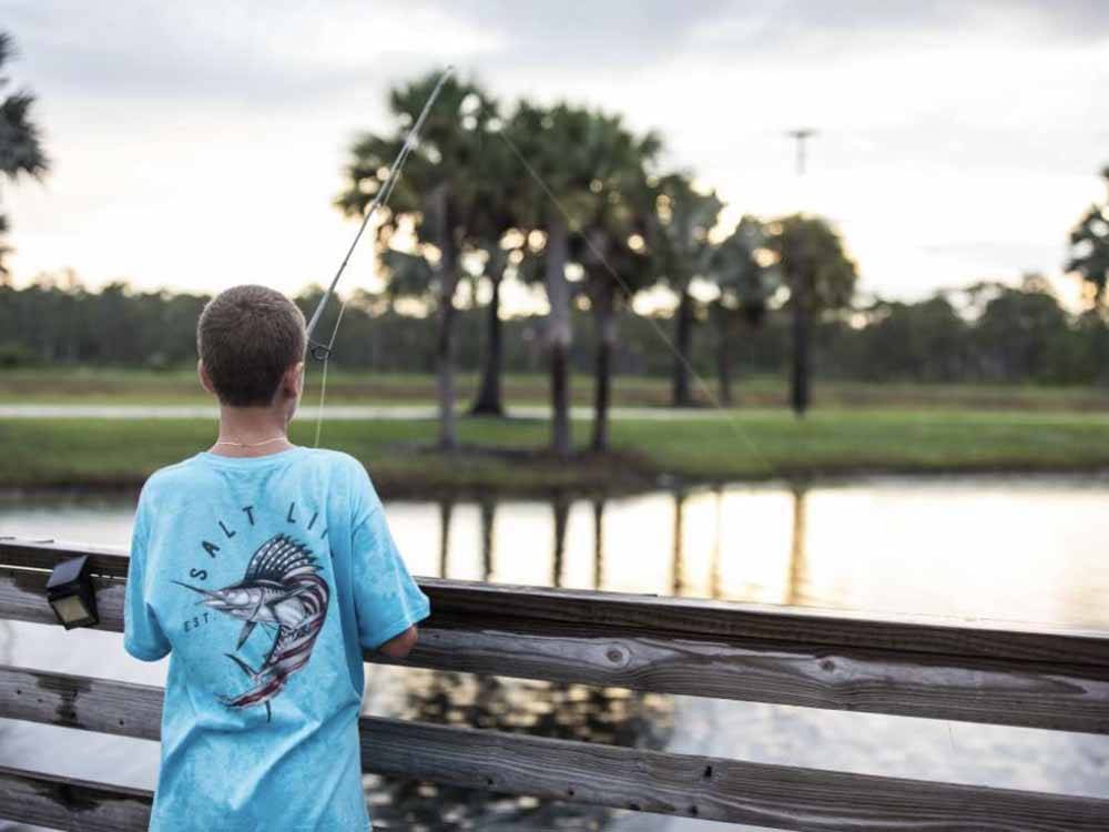 A boy fishing from the shore at RESORT AT CANOPY OAKS