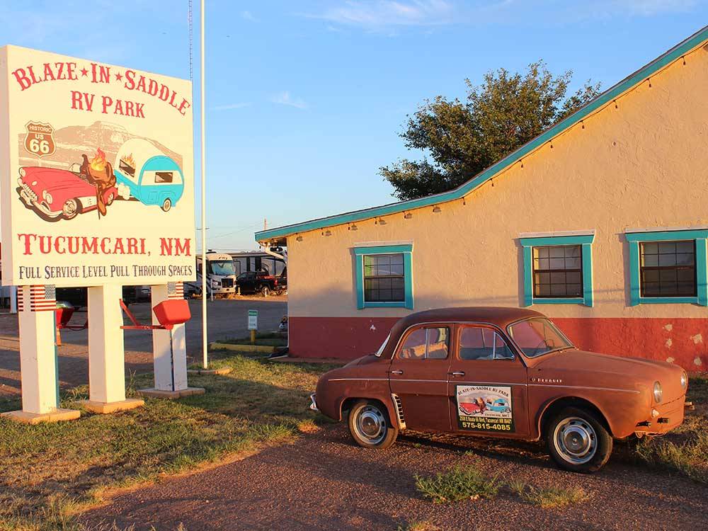 A vintage car by the park sign at BLAZE-IN-SADDLE RV PARK