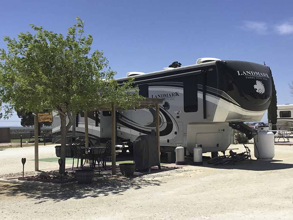 A fifth wheel trailer in a gravel RV site at HILLTOP RV PARK