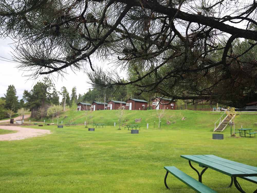 Camping cabins overlooking the grassy RV sites at FIREHOUSE CAMPGROUND