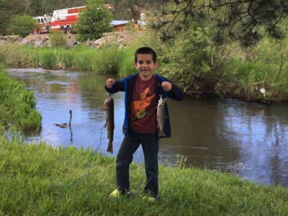 Child holding 2 fish caught in the river at FIREHOUSE CAMPGROUND