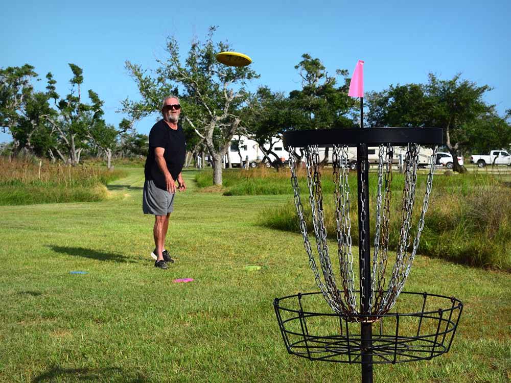 A man throwing a fisbee playing disc golf at QUILLY'S BIG FISH RV PARK