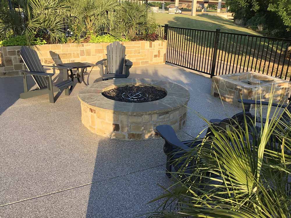 A fire pit with chairs and tables around it at LAKESHORE RV RESORT