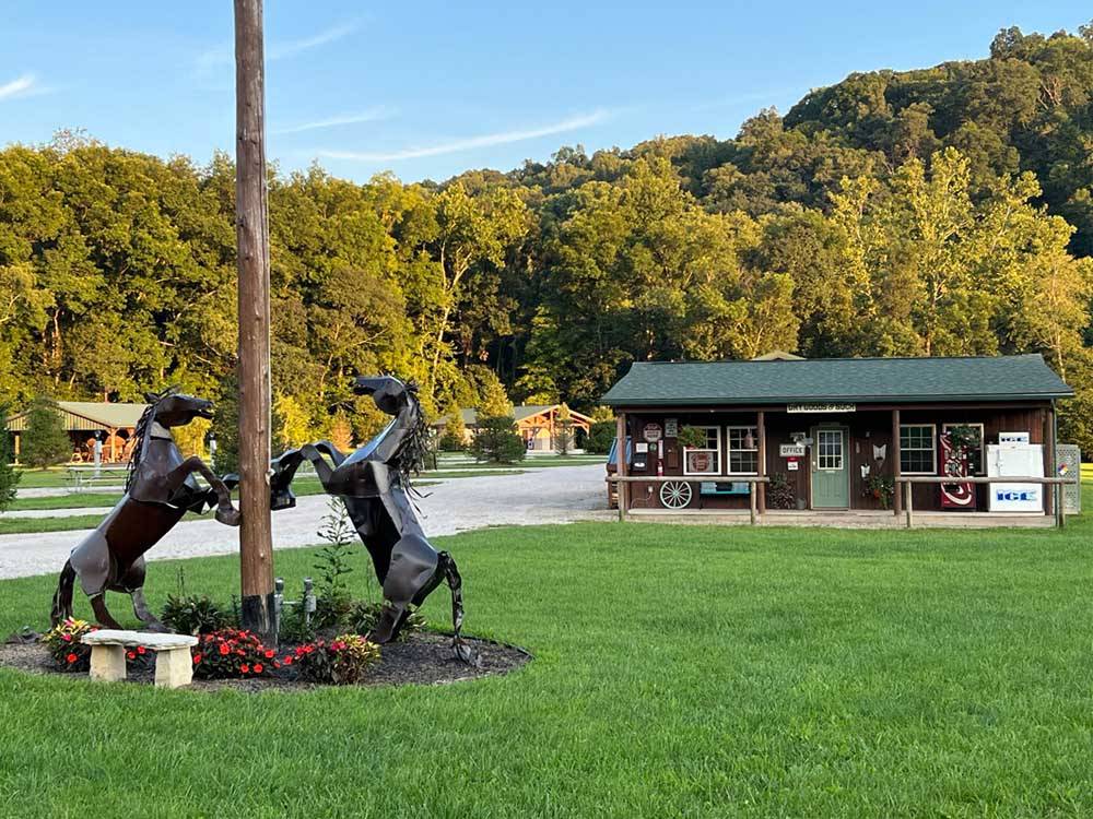 Statues of rearing horses near flagpole in front of campground building at PINE CREEK CABINS AND CAMPGROUND
