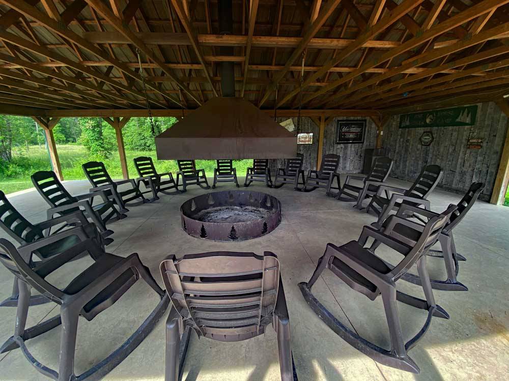 Rocking chairs surrounding a fire ring at PINE CREEK CABINS AND CAMPGROUND