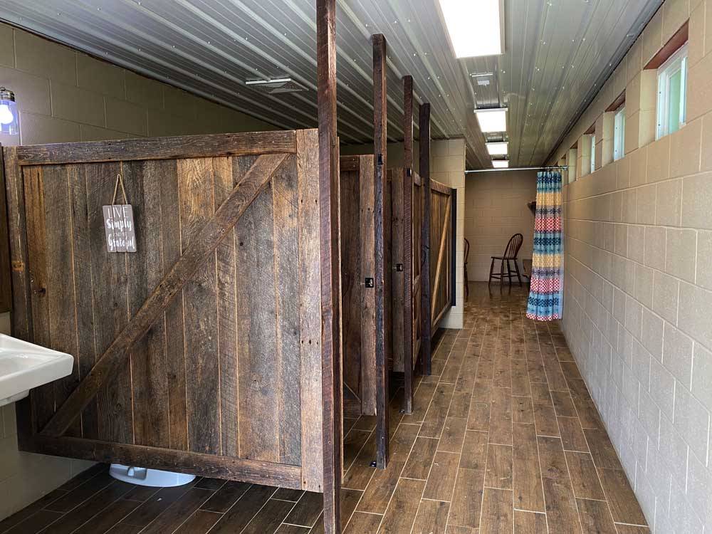Restroom stalls with tiled floor at PINE CREEK CABINS AND CAMPGROUND