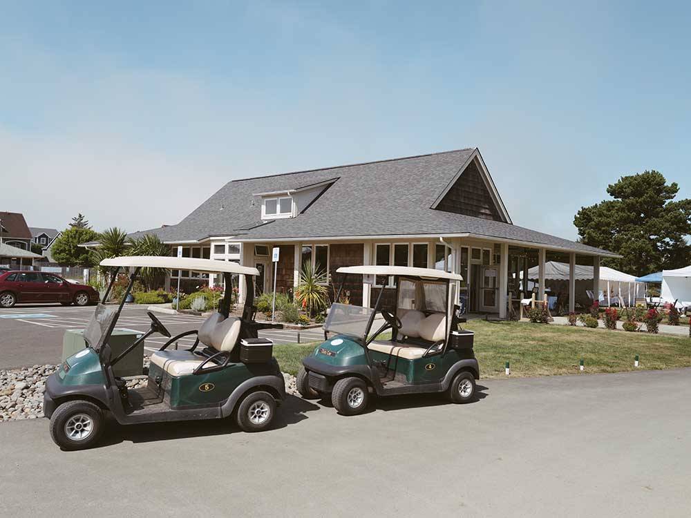 A pair of golf carts in front of the main building at WALLICUT RIVER RV RESORT