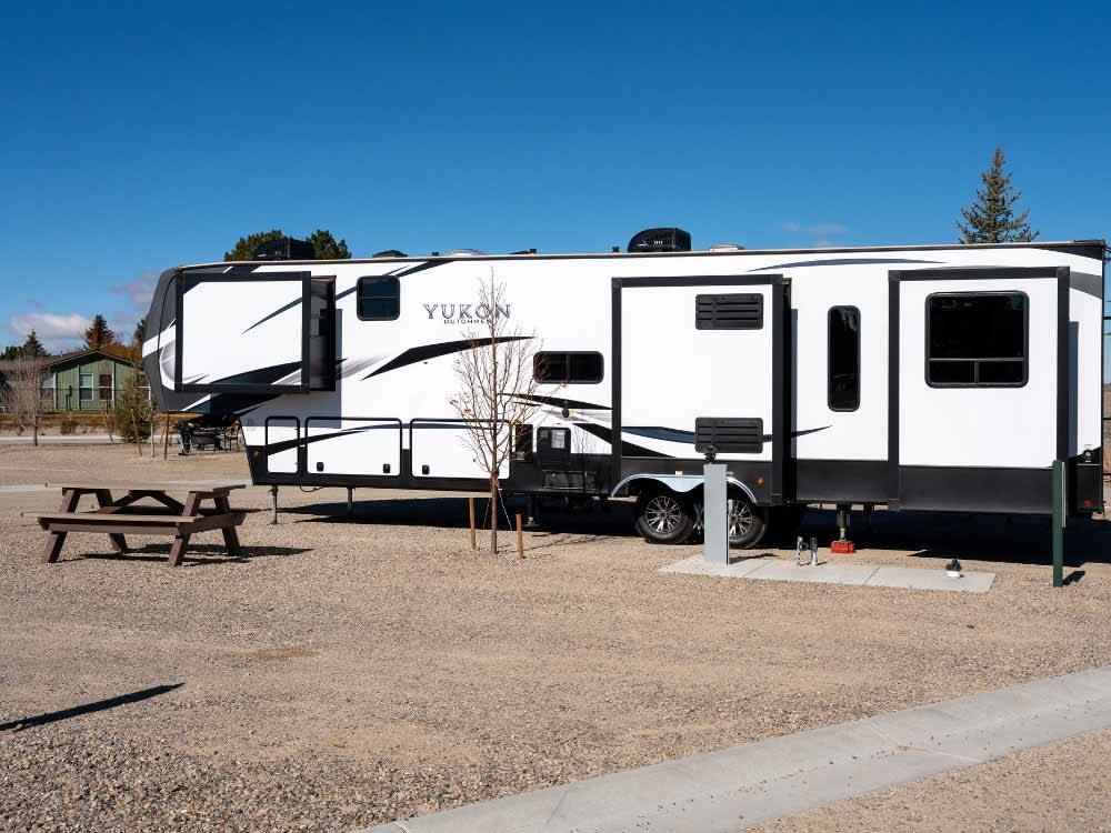 A Yukon fifth wheel trailer next to picnic bench at LITTLE AMERICA RV PARK