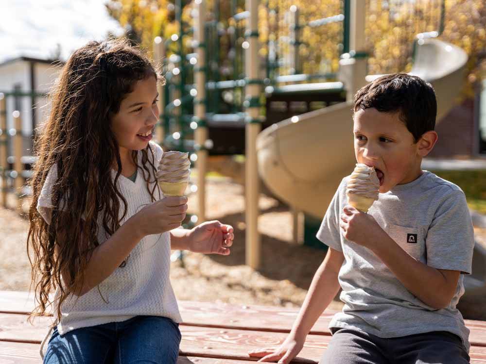 The young girl and boy enjoying ice cream cones at LITTLE AMERICA RV PARK
