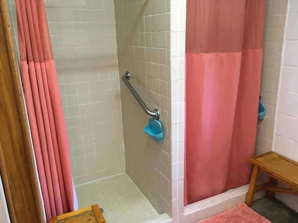 The shower stalls with salmon color curtains at CLOUD NINE RV PARK