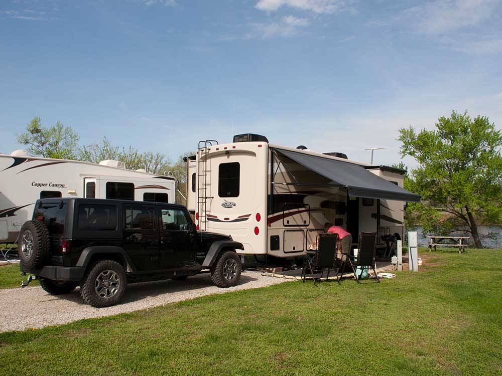 Motorhome in campsite with dinghy sharing space at DENTON FERRY RV PARK & CABIN RENTAL