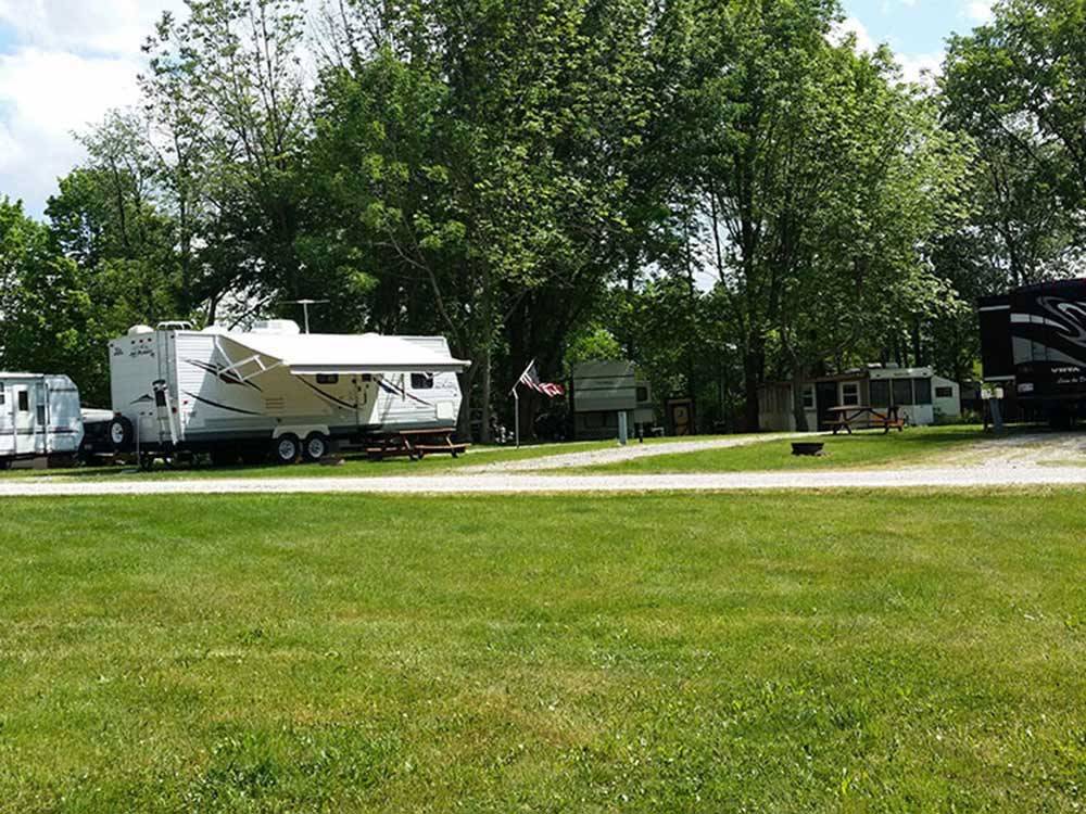 A grassy lawn next to a group of RV sites at COUNTRYSIDE CAMPGROUND