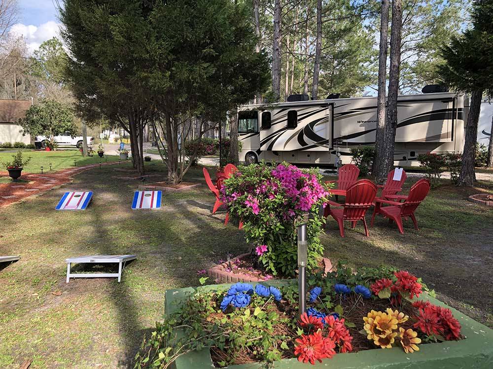 RV parked in site with cornhole game and seating area at LAKE CITY RV RESORT