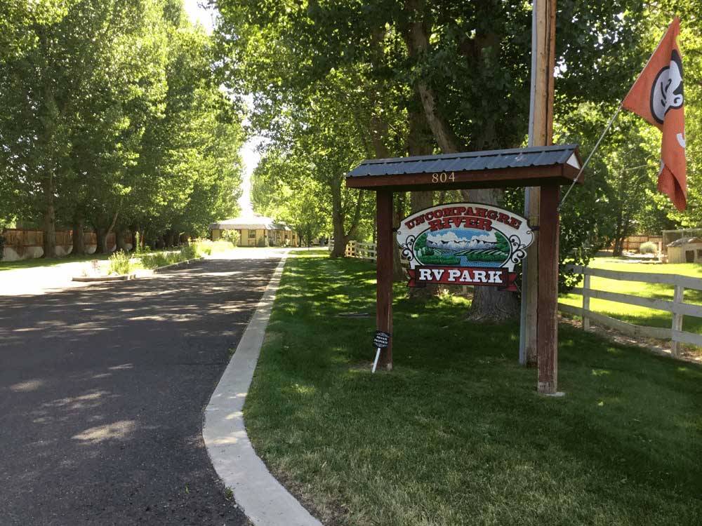 Sign at the tree lined park entrance at UNCOMPAHGRE RIVER ADULT RV PARK