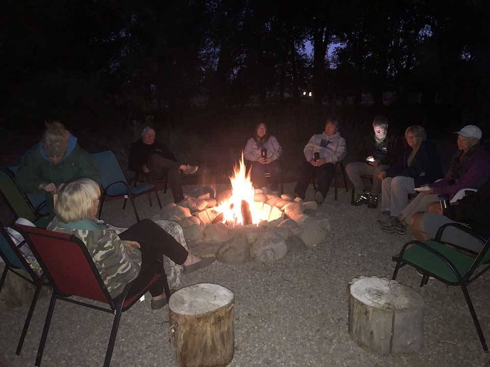 Group gathered in front of fire at UNCOMPAHGRE RIVER ADULT RV PARK