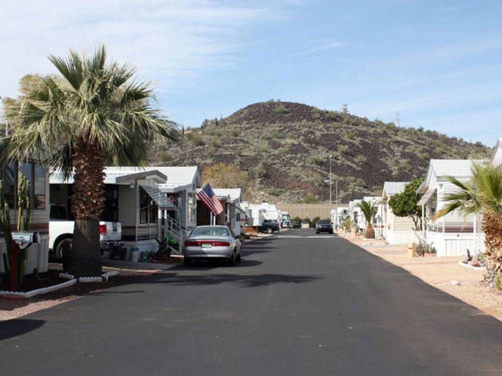 Mobile homes along asphalt road at PHOENIX METRO RV PARK