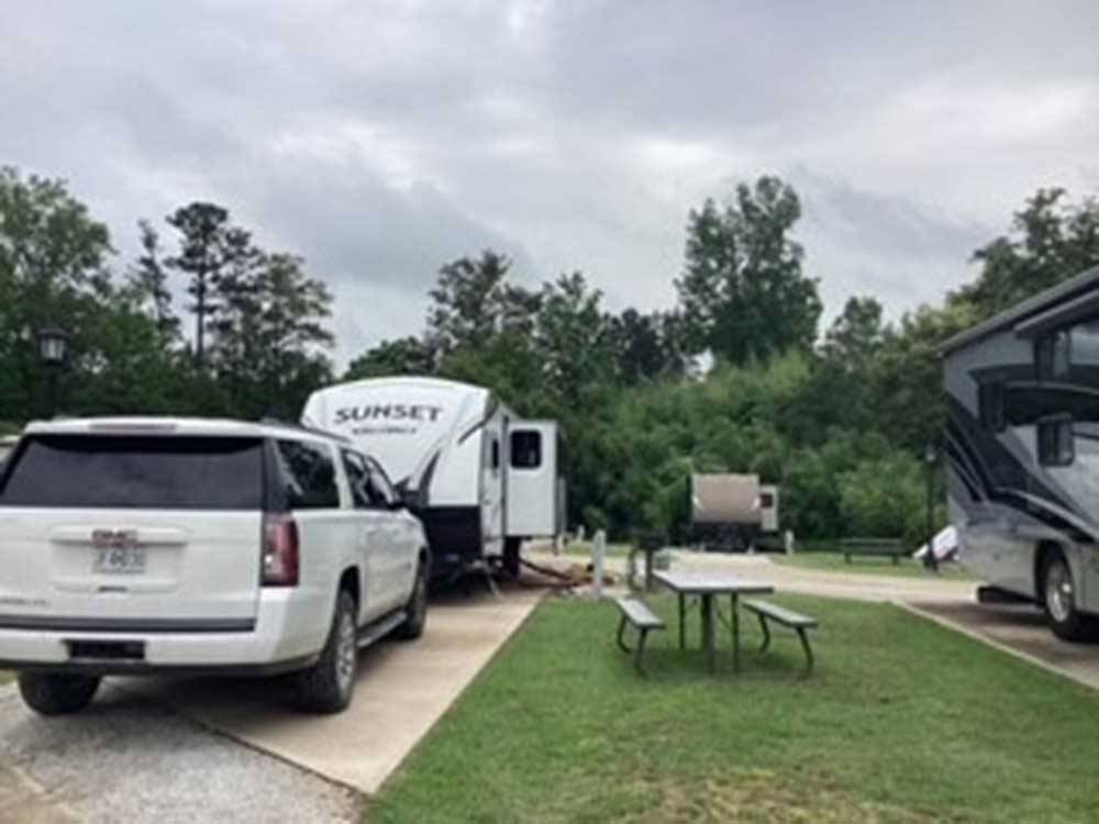 A trailer and SUV parked in a site at EAGLE'S LANDING RV PARK