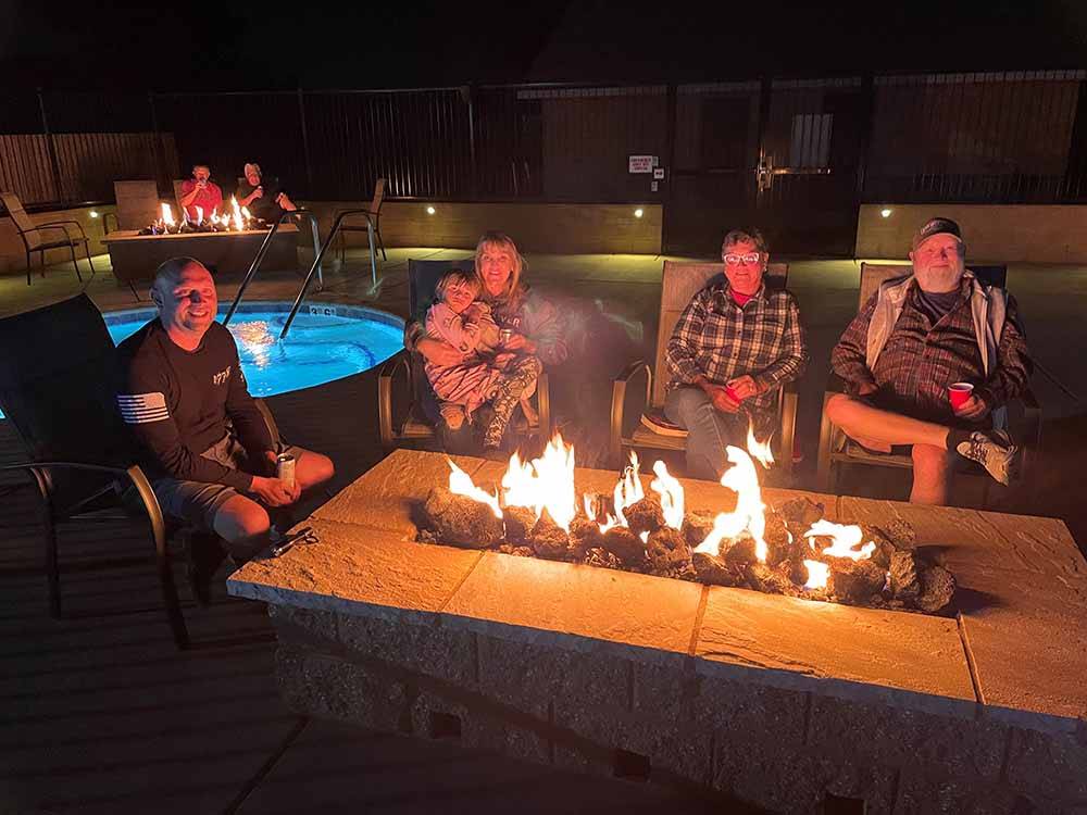 People sitting around a gas fire pit at KINGS RIVER RV RESORT