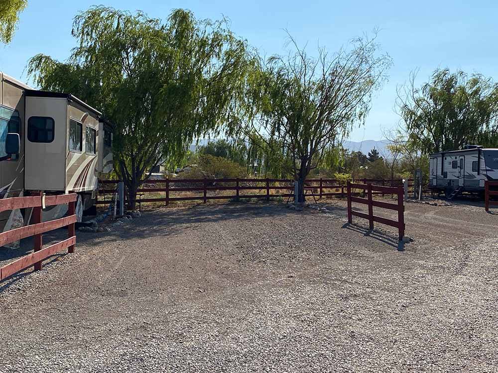 A gravel RV site with a fence at BOOT HILL RV RESORT
