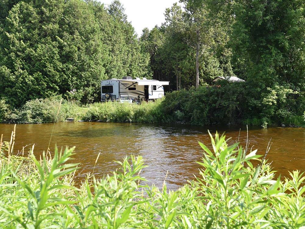 A travel trailer near banks of a stream at SAUGEEN SPRINGS RV PARK