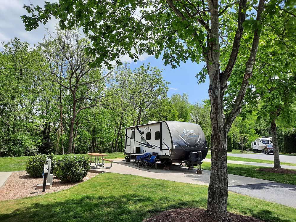 A fifth wheel trailer parked in a concrete site at PINE MOUNTAIN RV PARK BY THE CREEK