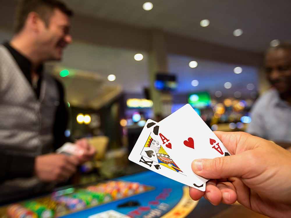 A person holding up two playing cards at LITTLE RIVER CASINO RESORT RV PARK