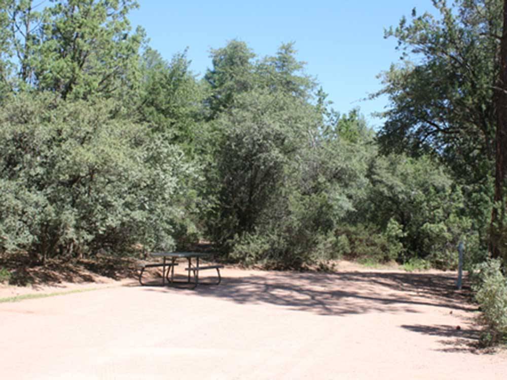 A dusty tree lined RV site at PAYSON CAMPGROUND AND RV RESORT
