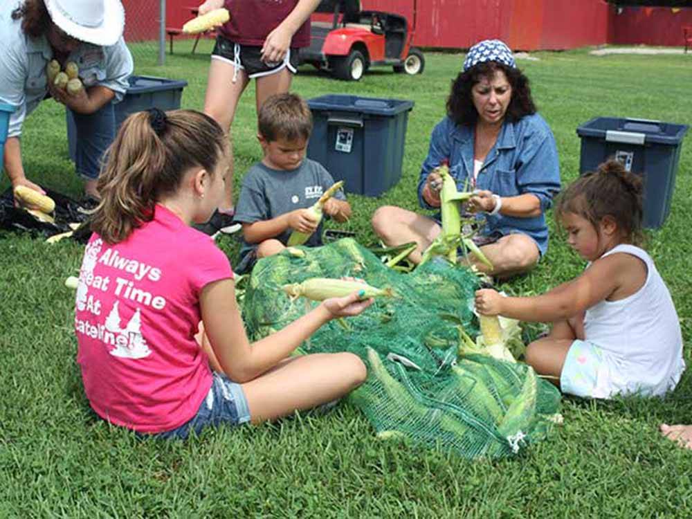 Group of children shucking corn at STATELINE CAMPRESORT & CABINS