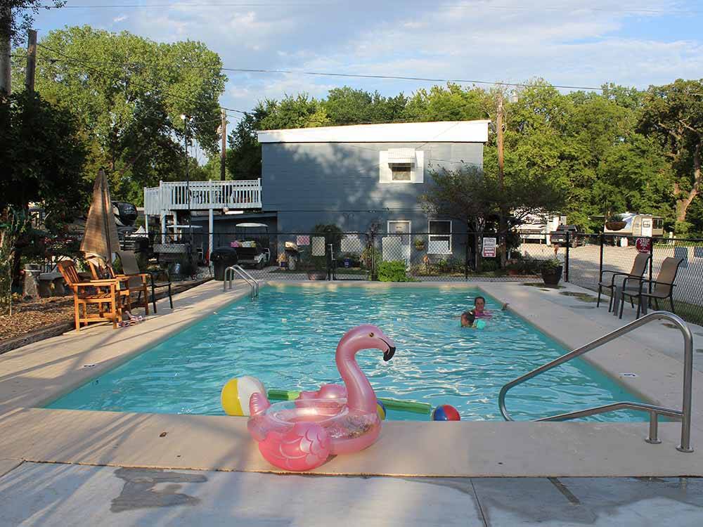 An inflatable pink flamingo by the swimming pool at RIVERSIDE RV PARK