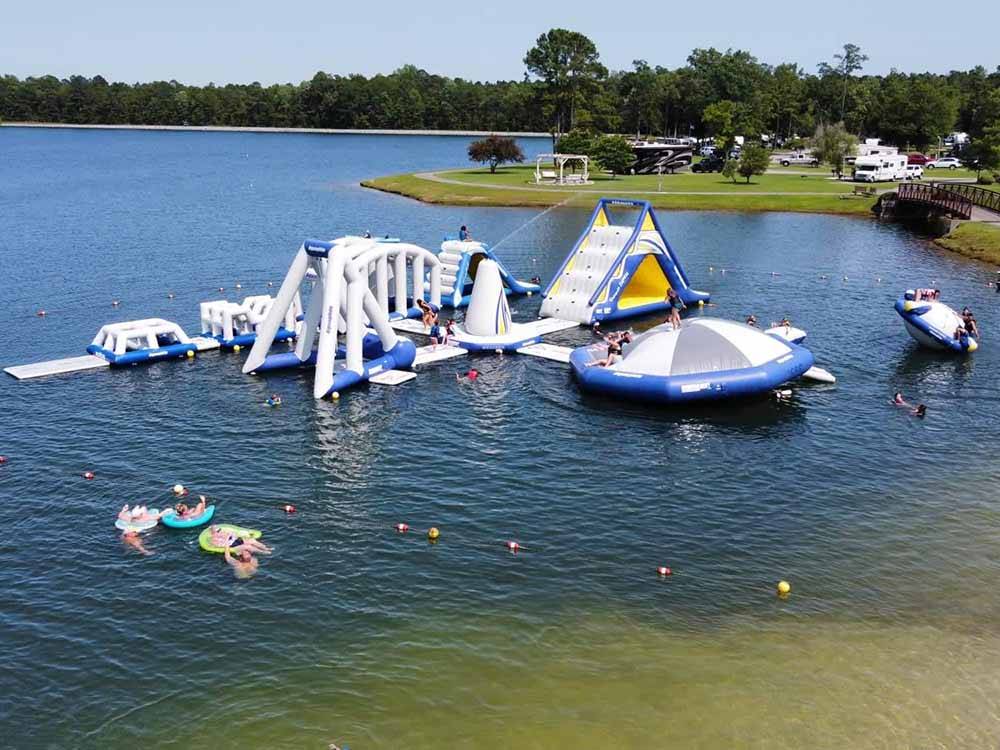 Play structures floating in a calm lake at WILLOWTREE RV RESORT & CAMPGROUND