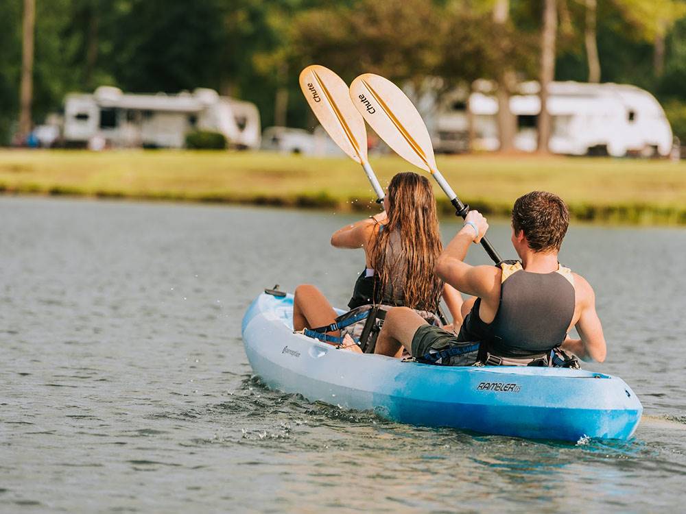 Young man and woman in a light blue kayak at WILLOWTREE RV RESORT & CAMPGROUND
