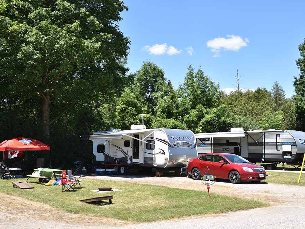 A travel trailer and car in a back in site at EMERALD LAKE TRAILER RESORT & WATERPARK