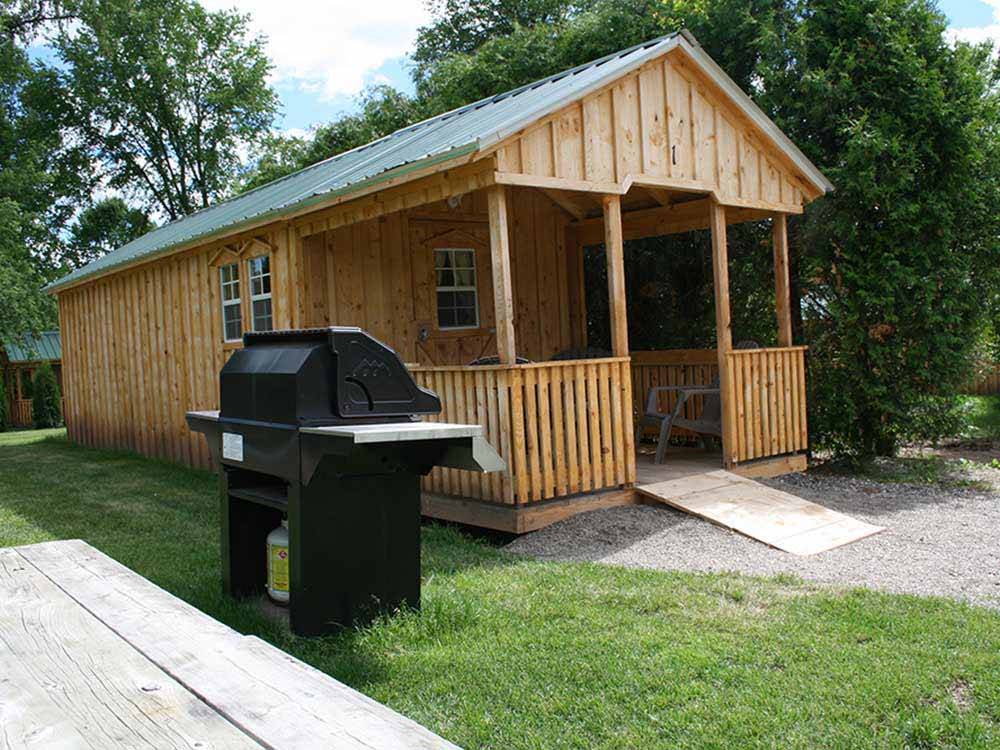 One of the rental cabins with a BBQ pit at EMERALD LAKE TRAILER RESORT & WATERPARK