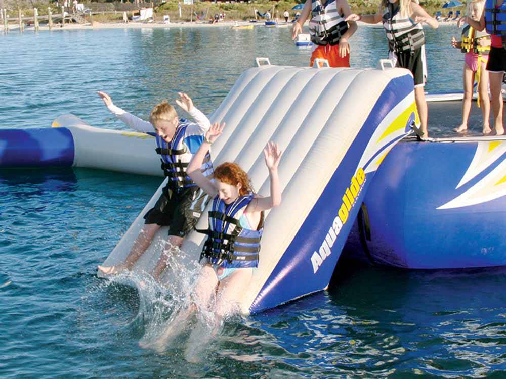 Kids sliding down a slide in the water park at EMERALD LAKE TRAILER RESORT & WATERPARK