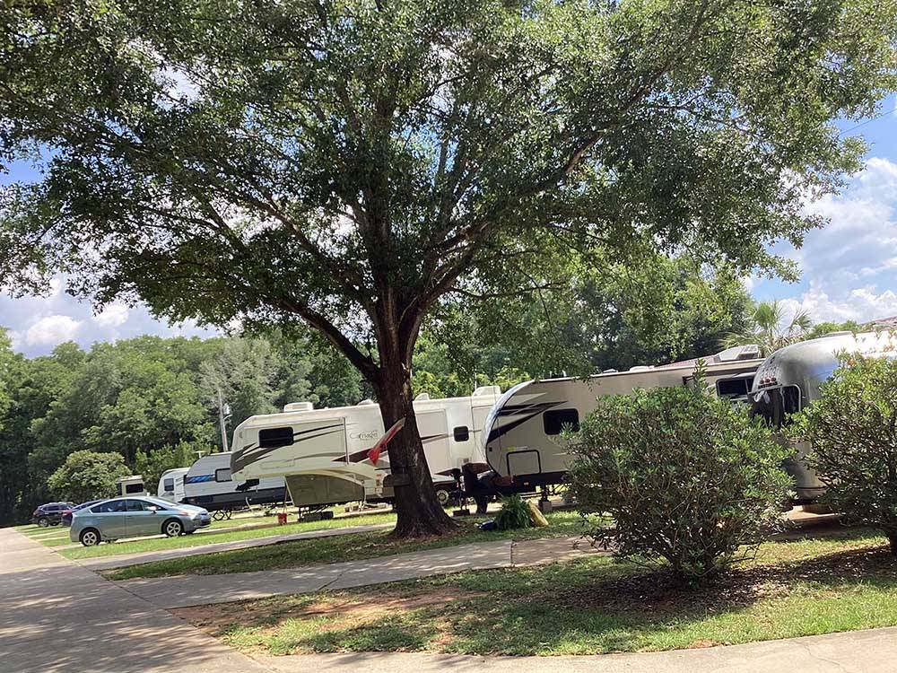 A row of travel trailers in paved sites at RV HIDEAWAY CAMPGROUND