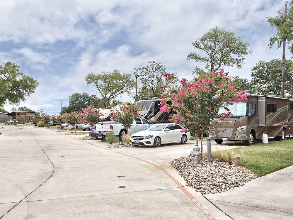 A row of cars parked in front of their trailers and motorhomes at OAK FOREST RV RESORT