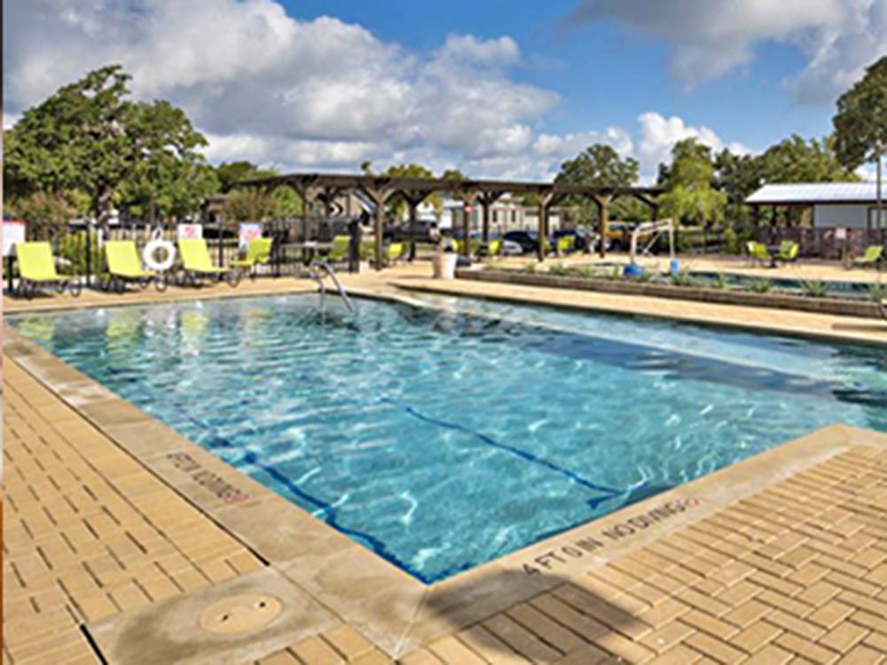 Large swimming pool with lounge chairs at OAK FOREST RV RESORT