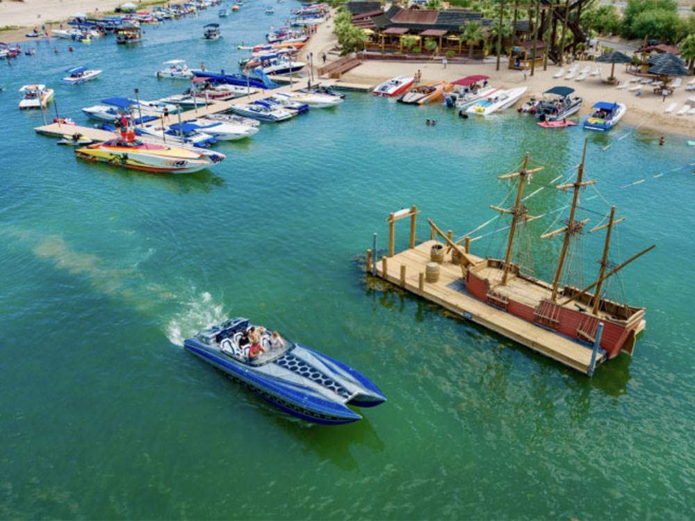 An aerial view of a boat driving by the dock in the middle of the river at PIRATE COVE RESORT & MARINA