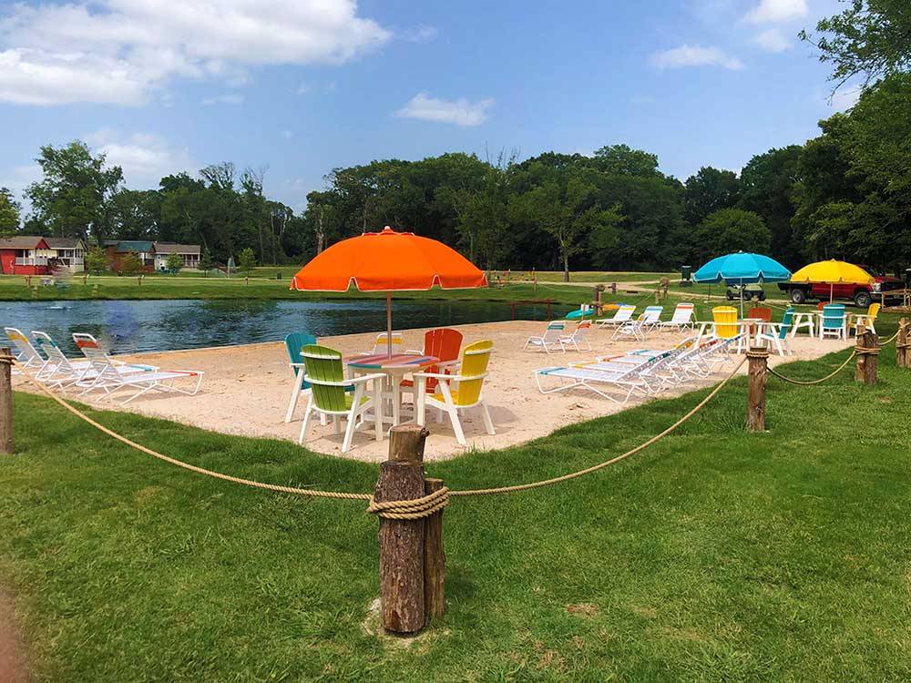 Colorful chairs and umbrellas next to the lake at MILL CREEK RANCH RESORT