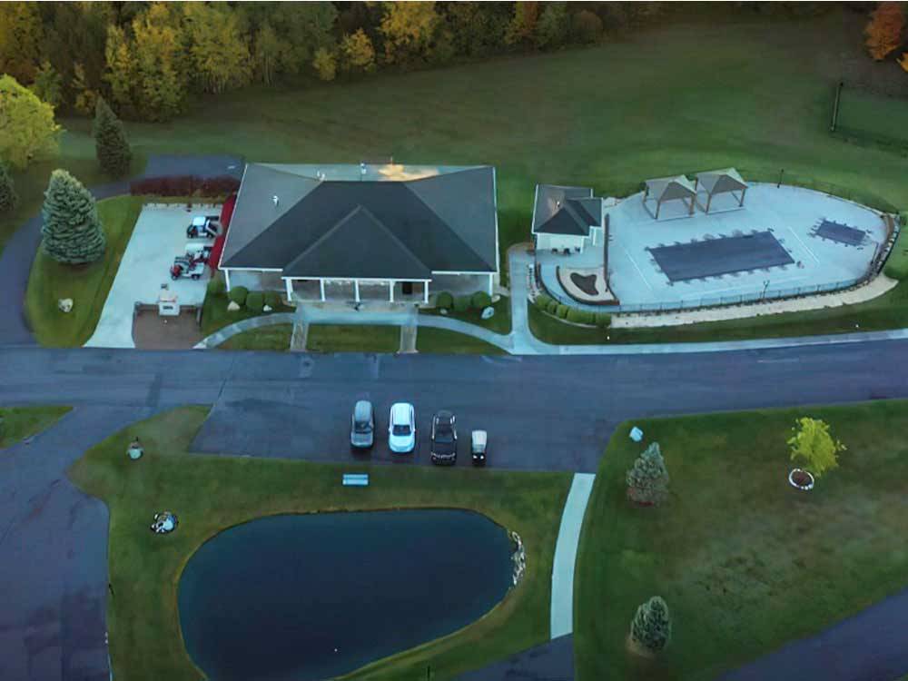 Aerial view of main building with pool and pond at TRAVERSE BAY RV RESORT