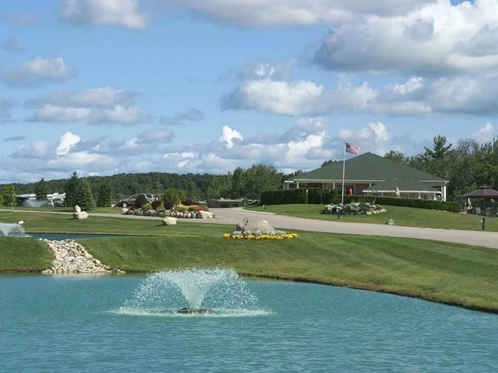 Shot of main building with pond in foreground at TRAVERSE BAY RV RESORT