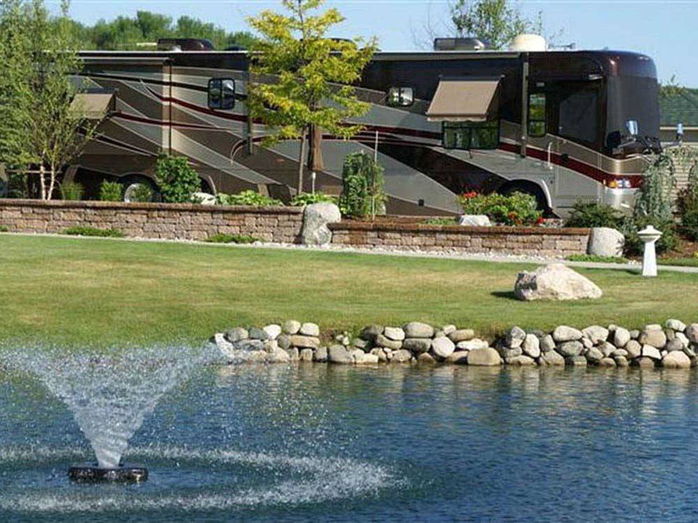 Motorhome in landscaped site near fountain at TRAVERSE BAY RV RESORT