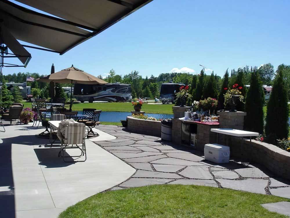 Expansive RV site patio overlooking a pond at TRAVERSE BAY RV RESORT